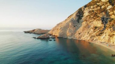 Kefalonia 'da gün batımında Petani Sahili uçurumları ve sakin deniz suları üzerinde uçuş.