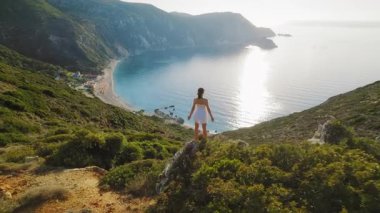 Güneşli bir yaz günü Petani Sahili 'ne bakan tepede duran bir kadın..