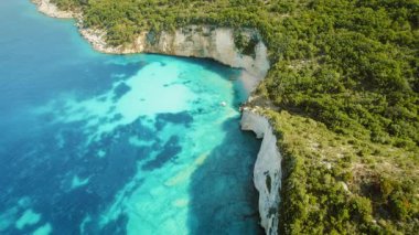 Kefalonya 'da güneşli bir yaz gününde yemyeşil orman kayalıkları olan mavi deniz.