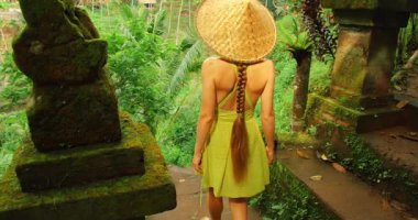 Bali Ormanı, Tegallalang 'daki yosunlu tapınak binalarının yanından geçen bir turist..