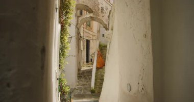 İtalya 'nın Amalfi kasabasındaki Akdeniz binaları arasında taş merdivenlerden inen bir kadın..