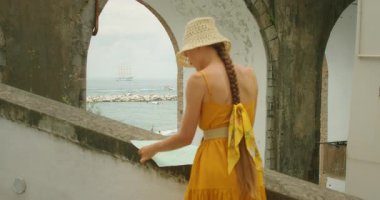 Gezgin, Atrani 'de kıyı açıklarında bir gemiyle kıyı kemeri yakınlarında harita okuyor..