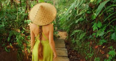 Güneydoğu Asya gezisi sırasında tropikal orman yolunda yürüyen bir kadın..