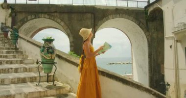 Haritalı bir kadın Amalfi Sahili 'ndeki deniz merdivenlerini güpegündüz keşfediyor. Atrani şehrinin kentsel ortamının tadını çıkaran bir turist..