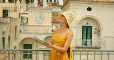 İtalya 'da Atrani şehrinin tarihi saat kulesinin yanında haritalı bir turist..