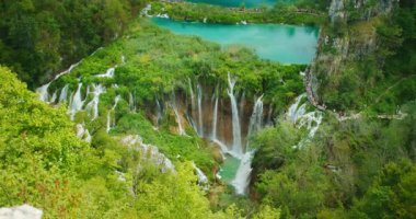 Plitvice Gölleri 'ndeki yemyeşil ormanlardaki çoklu şelale ve turkuaz göllerinin manzarası.