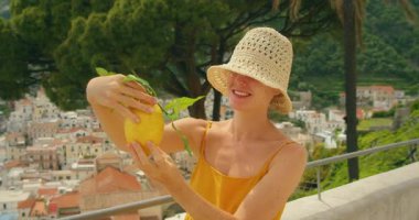 Amalfi İtalya turu sırasında elinde büyük bir limonla gülümseyen kadın Sfusato Amalfitano.