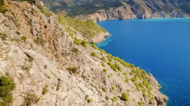 Dramatik sahil kayalıkları ve derin mavi Kefalonia denizi yüksek bir bakış açısıyla görülüyor..