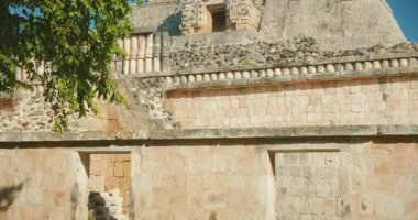 Yucatan Meksika 'da sütunları ve detaylı taş duvarları olan Uxmal harabelerinin manzarası.