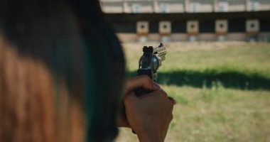 Nişancı kadın atış poligonundaki uzak hedeflere nişan alıyor ve ateş ediyor..