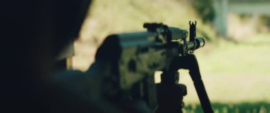 Nişancı gündüz eğitiminde dürbünlü tüfekle nişan alıyor..