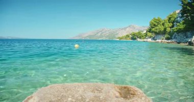 Hırvatistan 'da şamandıralı ve kayalık kıyı şeridine sahip kristal berrak deniz suyu.