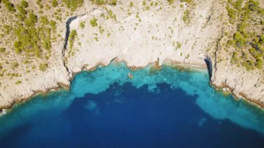 Turkuaz kıyı şeridinin yukarısındaki kayalık Cephalonia yamacındaki Assos Kalesi 'nin hava manzarası..