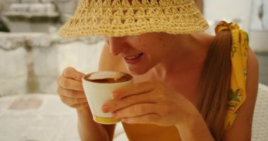 İtalya 'nın Amalfi kasabasında bir kafede cappuccino içerken gülümseyen bir kadın..