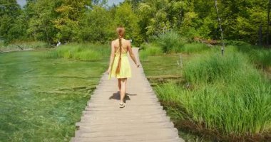 Yazın Plitvice Ulusal Parkı 'nda kaldırımda yürüyen bir kadın..