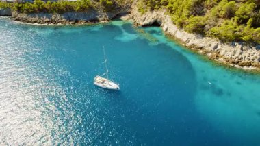 Yaz günü Kefalonia adasındaki turkuaz bir körfeze demir atmış bir yelkenli..