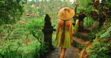 Kadın, Tegelalang pirinç tarlalarındaki yemyeşil orman patikası boyunca taş kapıdan girer..