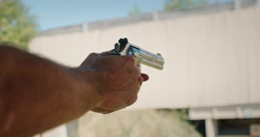 Atış talimi sırasında dışarı nişan alıp ateş eden bir adam..