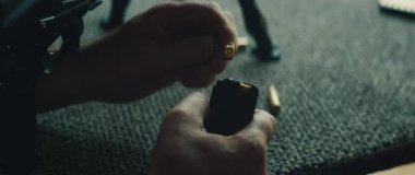 Atış talimi sırasında dışarıdaki atış poligonunda eller mermiyi şarjöre yüklüyor.