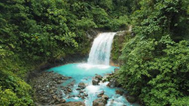 Kosta Rika yağmur ormanlarındaki parlak mavi havuz ve şelalenin yakın görüntüsü.