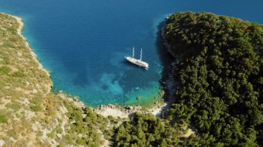 Yunanistan 'da yemyeşil ormanlarla çevrili tenha bir koyda demirli bir yat..