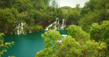 Şelaleler Plitvice Park Hırvatistan 'da sakin bir zümrüt göle akıyor.