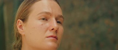 Kadının yakın çekimi, düşünceli ve düşünceli bir ifadeyle yukarı bakıyor..