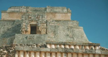 Açık mavi gökyüzüne karşı Uxmal 'de Nunnery Quadrangle' ın süslü dış cephesi.