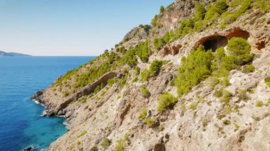 Yunanistan 'ın başkenti Cephalonia' daki Assos şatosuna uzanan çam ağaçları ve mağaraların bulunduğu Rocky kıyı dağ patikası.