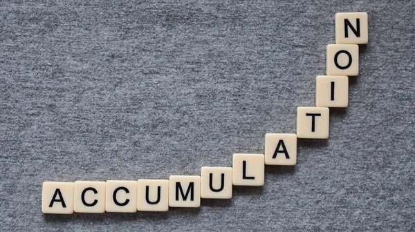 the word accumulation spelled in letters arranged as exponential function simulating exponential growth and compound interest on gray background with copy space
