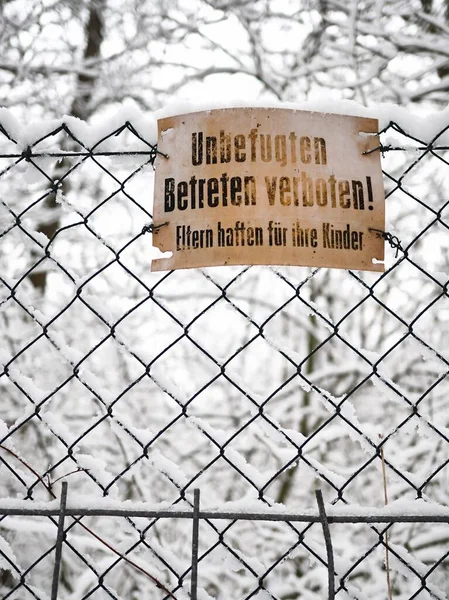 old do not enter sign at a fence at wintertime - unbefugten betreten verboten, eltern haften fr ihre kinder