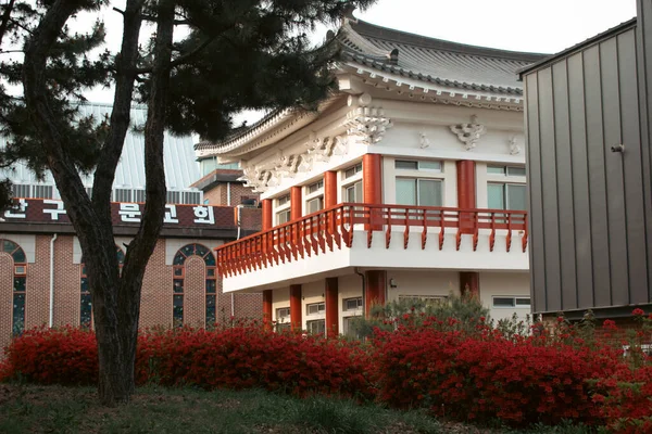 アジアンスタイルの建物 木や赤い花 — ストック写真