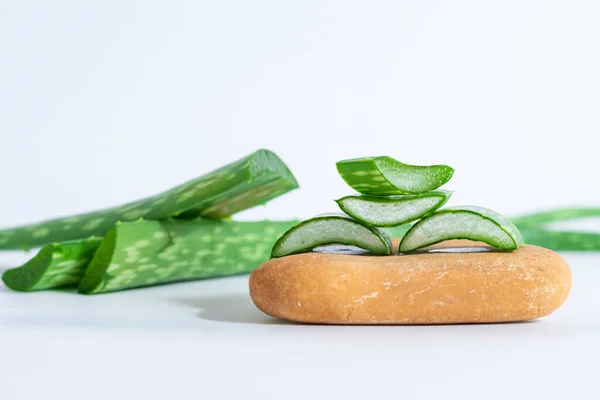 Aloe Vera spa taşlarını, zen taşlarını ya da çakıl taşlarını ahşap masaya koyar. Cilt bakımı kavramı.