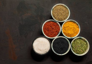 Geleneksel doğu baharatları seramik kaselerde. Kara kimyon tohumu, kırmızı biber, kurutulmuş nane, himalaya tuzu..