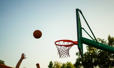 Basketbol oynayan insanlar ribaund almak için atlıyorlar.