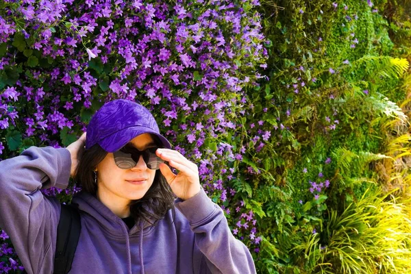 girl wearing purple clothes and sunglasses on a purple flowers wall