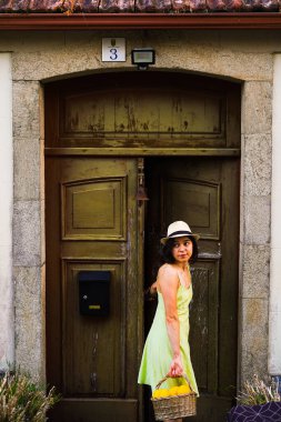 Bir sepet dolusu limonla çiftçilik yaptıktan sonra eve gelen genç bir kadın, kapının önünde bekliyor.