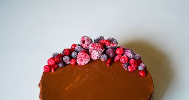 Beyaz arka planda kırmızı böğürtlenli lezzetli çikolatalı pasta.