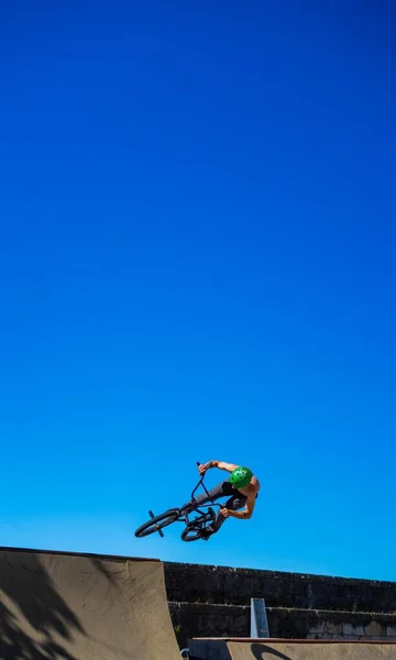 空にコピースペースのあるランプを飛び越える競争のBmxライダー — ストック写真