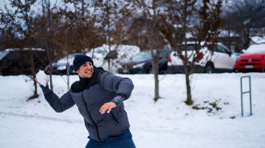 Karda kartopu atan bir adamın fotoğrafı.