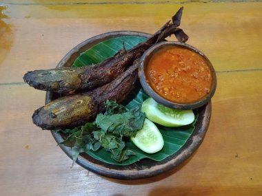 Endonezya yemeği olan Pecel Lele ya da sebze ve biber ezmesiyle servis edilen kızarmış yayın balığı..