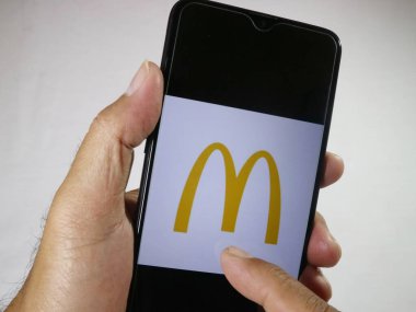 Parmak ile el ele tutuşan cep telefonu ekrandaki Mc Donald logosuna dokun. 