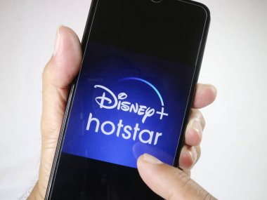 El ele tutuşan cep telefonuyla ekrandaki Disney Hotstar logosuna dokun. 