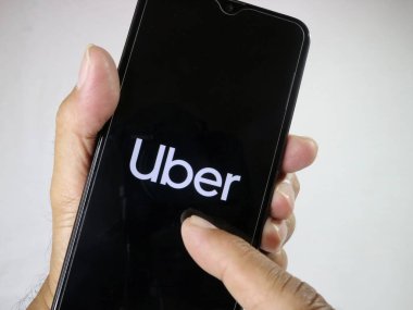 El ele tutuşan cep telefonu parmağıyla ekrandaki Uber logosuna dokun. 