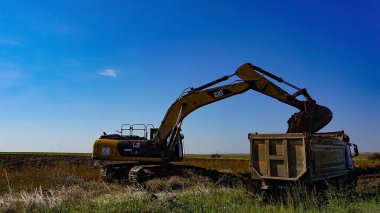 Chorlu, Türkiye - 24 Eylül 2022: Sarı Kedi endüstriyel kazıcı Chorlu yakınlarında çalışıyor. Caterpillar Inc., en büyük inşaat ve maden ekipmanı üreticilerinden biri olan bir Amerikan şirketidir..