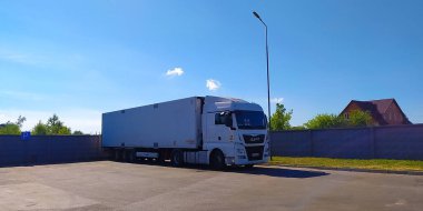 Vinnitsa, Ukrayna - 17 Nisan 2022: Karayolu yakınında konteynır taşıyan kamyoncu. MAN Truck and Bus SE Traton 'un bir yan kuruluşu ve ticari araçların önde gelen uluslararası sağlayıcılarından biridir..