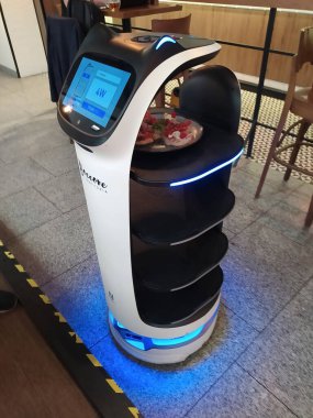 Krakow, Polonya - 22 Mayıs 2023: Garson robot tabakları John Paul II. Uluslararası Havalimanı Krakow-Balice 'deki Boccone Trattoria' ya getiriyor