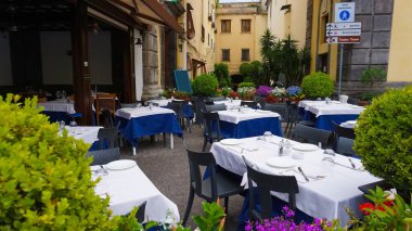 Sorrento, İtalya - 27 Mayıs 2023: Tipik Sorrento restoranı Ristorante Pizzeria L 'Abate tabanlı boş masalar.