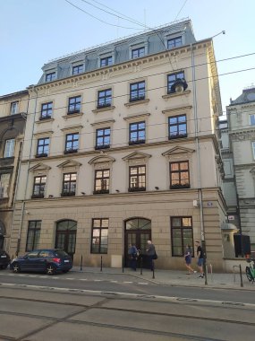 Krakow, Polonya - 22 Mayıs 2023: İnsanlar Krakow eski kasabasından tipik eski bina cephesine yaklaşıyorlar