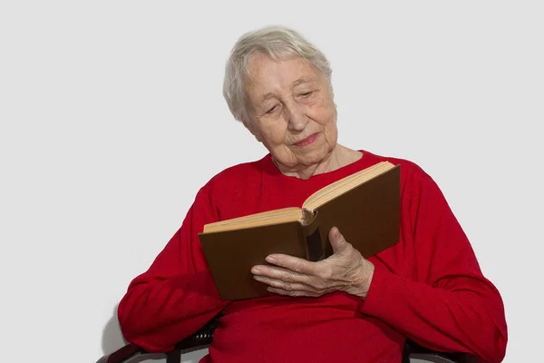 Счастливая Пожилая Женщина Седыми Волосами Читающая Книжку Улыбающаяся Отдыхая Дома — стоковое фото